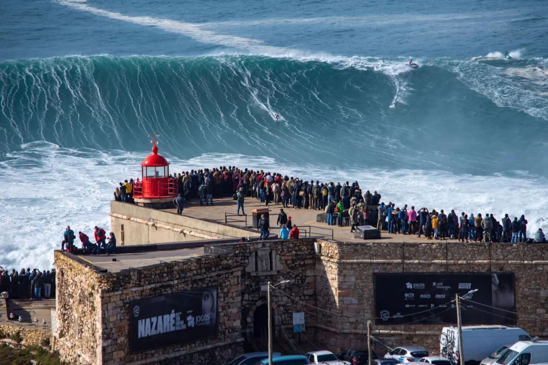 Red lighthouse on the Nazaré clifftop above the ocean
